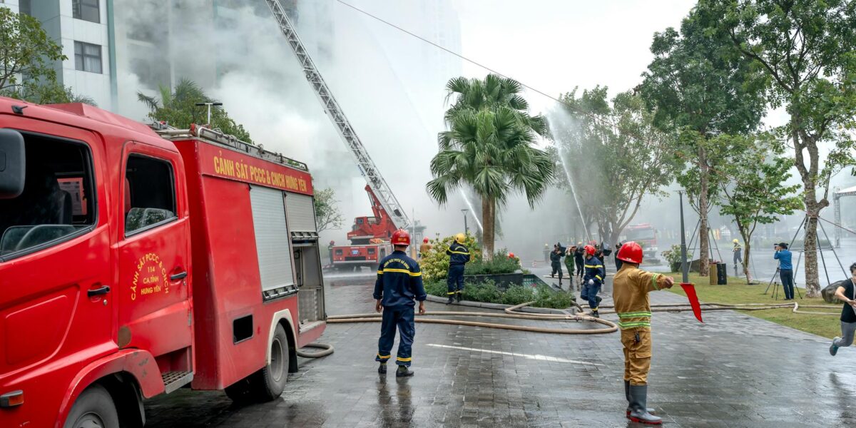 Firefighters in harnesses rescue stranded passengers from a stopped rollercoaster car, highlighting amusement park safety in action.