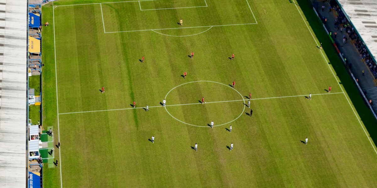 Young GAA players on field during All-Ireland minor finals, with Croke Park stands in background