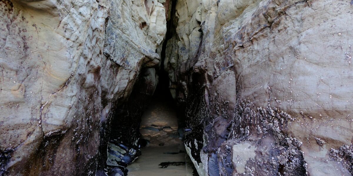 Rescue divers at a narrow cave entrance during the Laos cave rescue operation, with emergency lights illuminating the flooded passage.