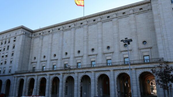 A Spanish flag waves in front of a courthouse in Madrid, symbolizing the ongoing Spain corruption probe shaking the government.